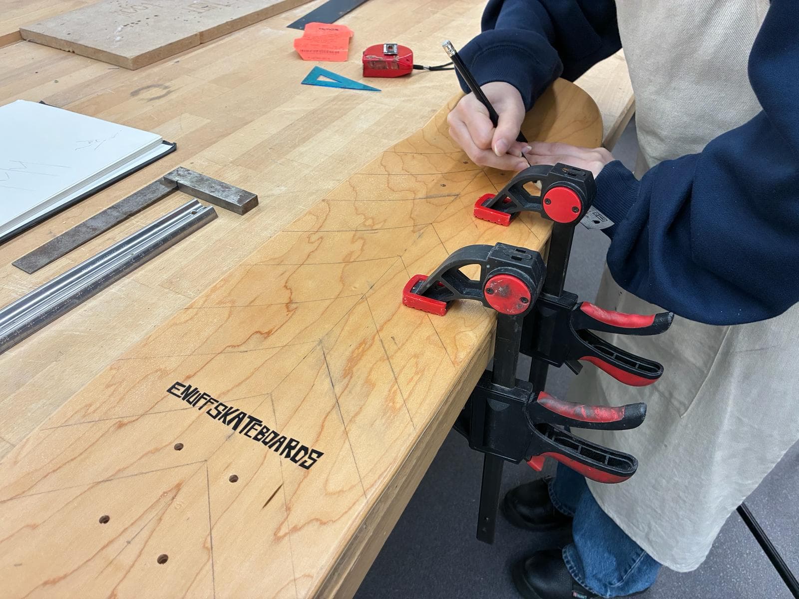 Chevron drainage geometry being marked onto the skateboard deck